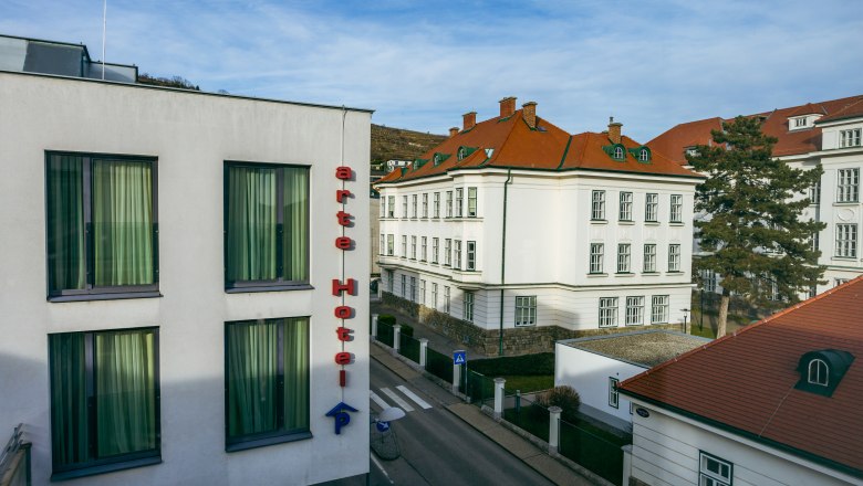 arte Hotel Krems, © Niederösterreich Werbung / Maximilian Pawlikowsky Außenansicht des arte Hotels in Krems mit umliegenden Gebäuden und Straße.