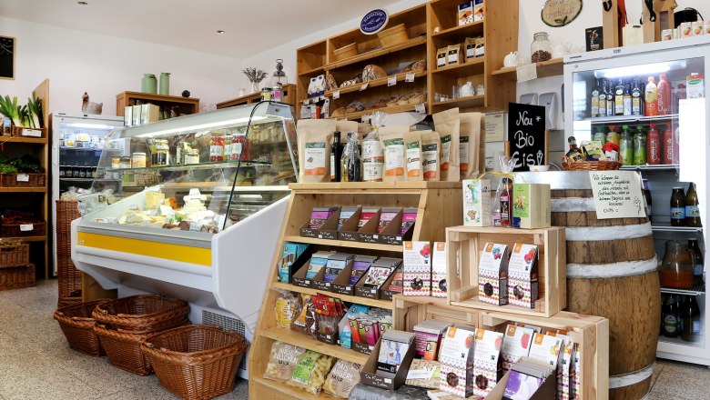 Gsunds Eck in Traismauer, © Evelyn Hochsteger Innenansicht eines kleinen Ladens mit Regalen voller Bio-Produkte und einer Kühltheke mit Käse.