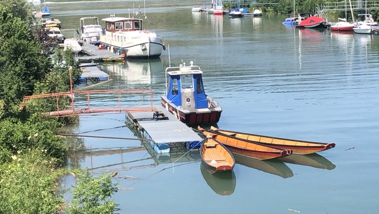 Anlegesteg beim Hafenwirt in der Erlaufmündung in Pöchlarn, © Donau NÖ Tourismus GmbH Boote an einem Anlegesteg in einem ruhigen Hafen mit grüner Umgebung.