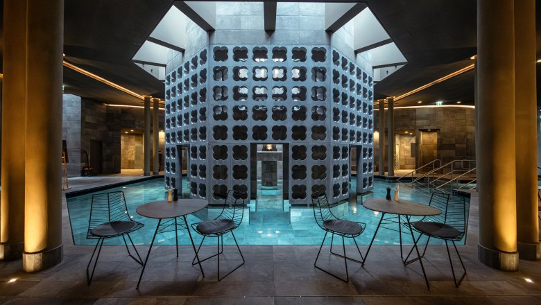 Therme Laa | Hotel | Silent Spa | Villas, © Niederösterreich Werbung / Maximilian Pawlikowsky Innenansicht eines modernen Spas mit Pool, Tischen und Stühlen.