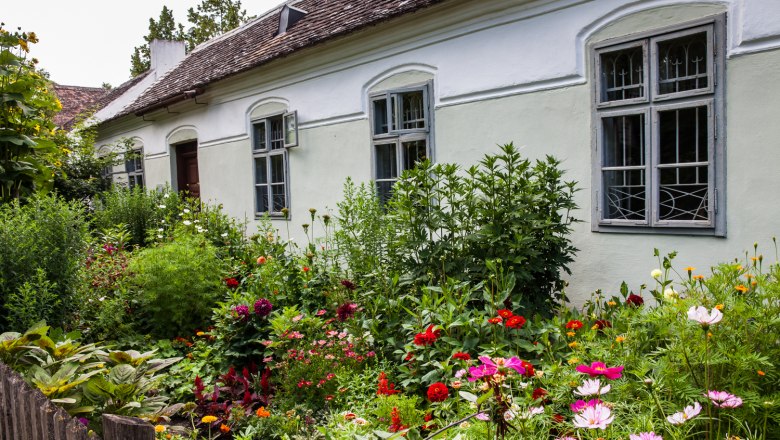 Vorgärten im Museumsdorf Niedersulz, © Nadja Meister Ein traditionelles Haus mit einem bunten Blumengarten im Vordergrund im Museumsdorf Niedersulz.