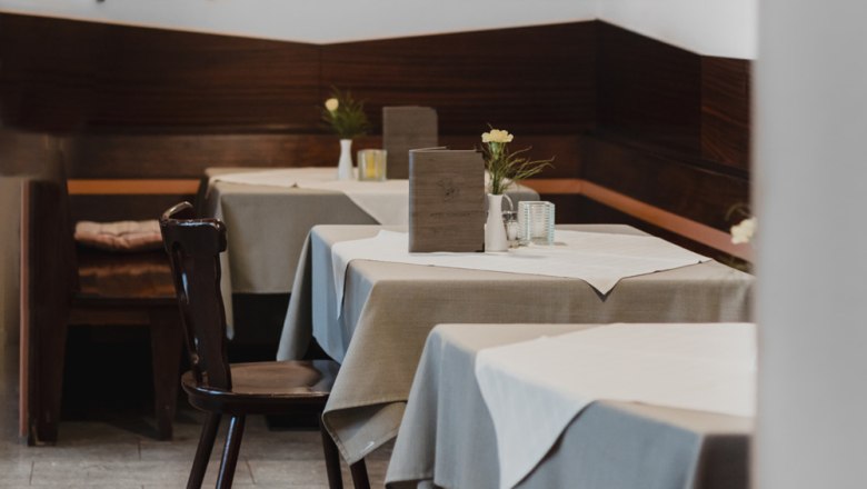 Fichten-Stüberl oder grüner Hofgarten, © Niederösterreich Werbung/David Schreiber Innenansicht eines gemütlichen Restaurants mit Holzmöbeln und gedeckten Tischen.