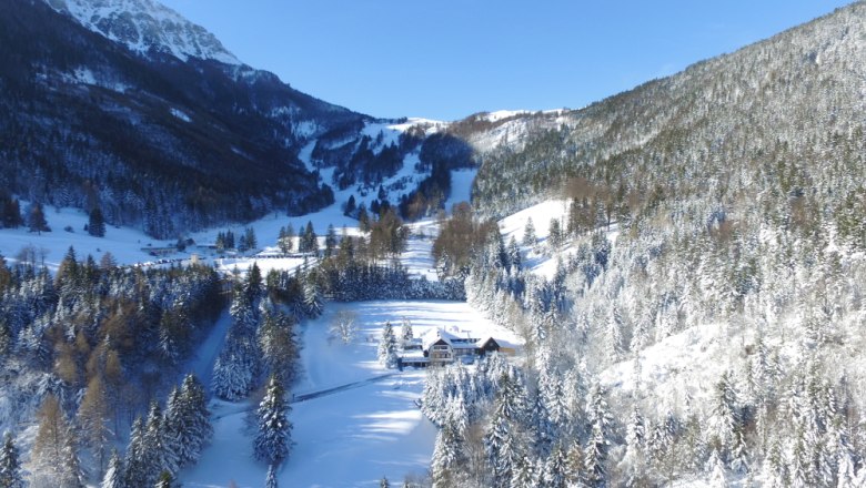 Gschaiderhof Winter, © Marianne Gschaider Winterlandschaft mit verschneiten Bergen und einem Hof im Tal.