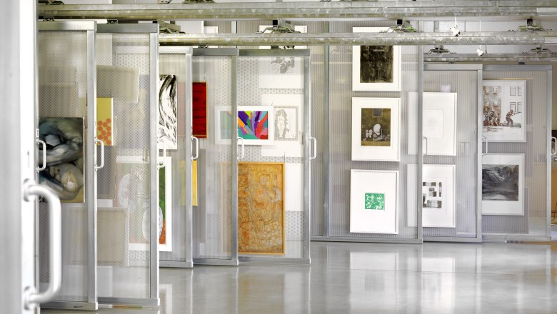 Artothek, © Birgit und Peter Kainz Innenansicht einer Artothek mit Kunstwerken in verschiebbaren Regalen.