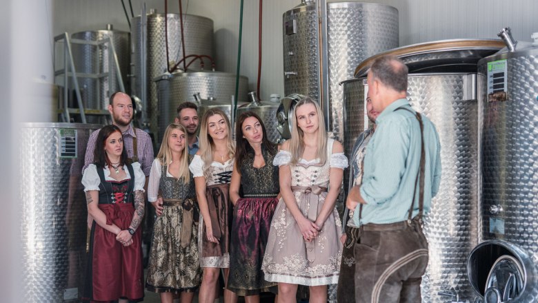 Winzerhof Küssler, © Winzerhof Küssler Gruppe von Menschen in traditioneller Kleidung in einer Brauerei.