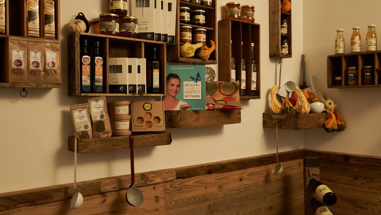 Genuss MEISTEREI Heiligeneich, © Philipp Monihart – www.charakter.photos Regale mit Lebensmitteln und Kochutensilien an einer Holzwand.