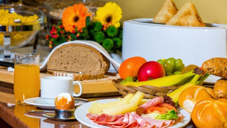 Frühstücksbuffet, © Stadthotel Hollabrunn Frühstücksbuffet mit Brot, Aufschnitt, Käse, Obst, Brötchen, Saft und Ei.