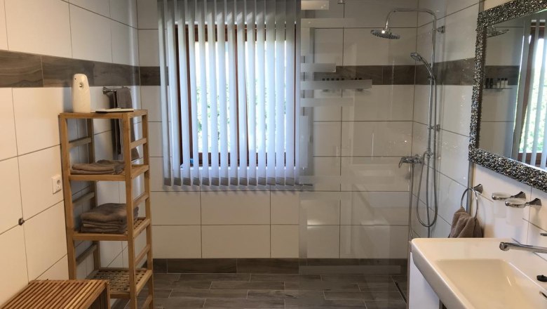 Badezimmer, © Familie Mokesch Modernes Badezimmer mit Dusche, Waschbecken, Spiegel und Regal.