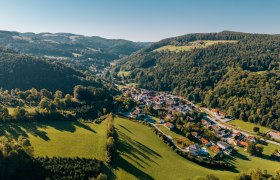 Gemeinde Edlitz, © Wiener Alpen, Roman Königshofer Photography Luftaufnahme von Edlitz mit Wehrkirche und umliegender Landschaft.