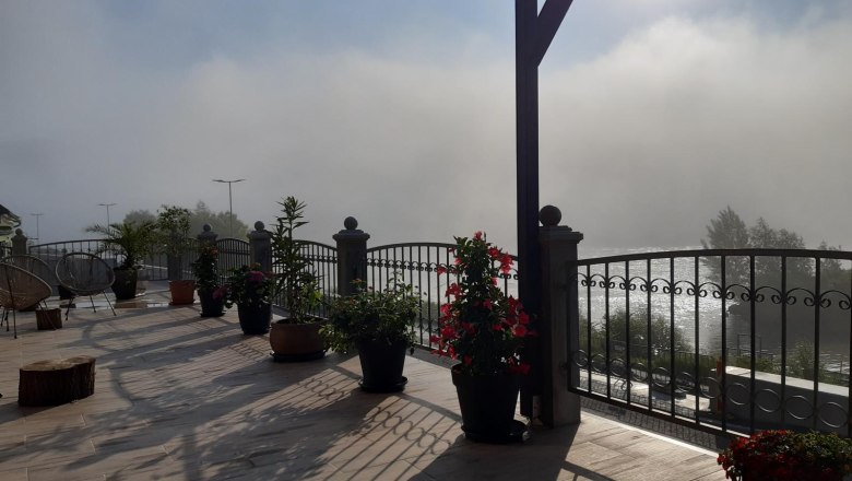 Ausblick von der Terrasse im Nebel, © Georg Smolka Terrasse mit Pflanzen, Geländer und Nebel im Hintergrund.
