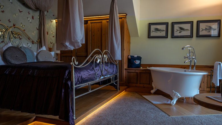 Hotel ResidenzWachau, © Niederösterreich Werbung / Maximilian Pawlikowsky Luxuriöses Hotelzimmer mit Himmelbett und freistehender Badewanne.