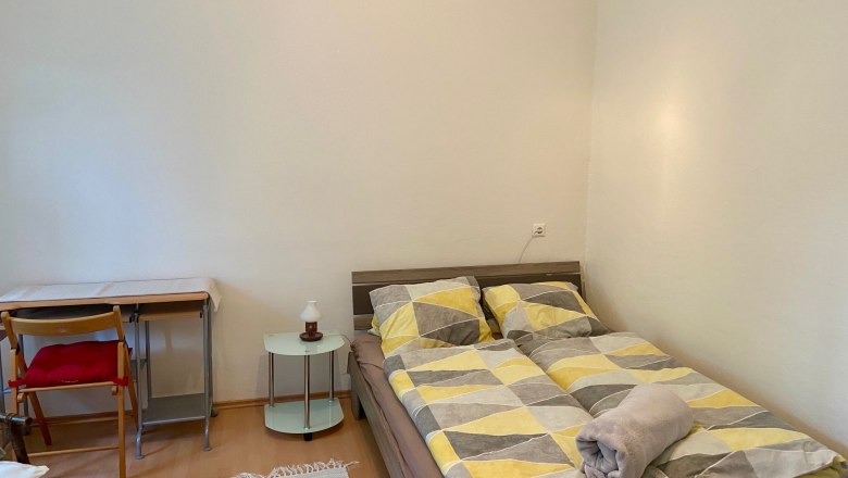 Schlafzimmer(c)wieneralpen, © Wiener Alpen Schlafzimmer mit Doppelbett, Schreibtisch und Stuhl.