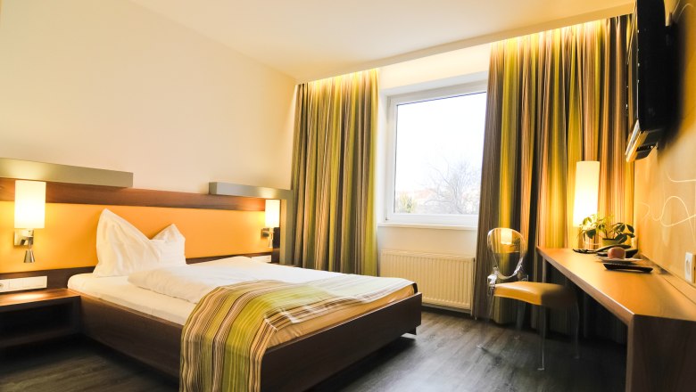 Motel Baden, © Motel Baden Modernes Hotelzimmer mit Doppelbett, Schreibtisch und großem Fenster.