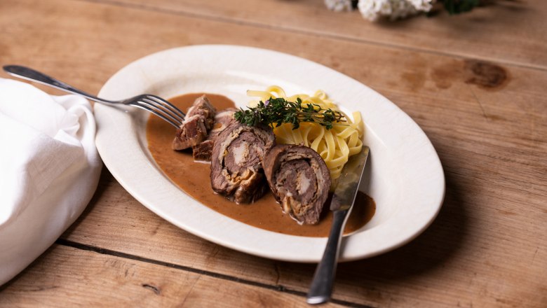 Gerollter Rostbraten mit Schwammerlfülle, hausgemachte Nudeln, © Niederösterreich Werbung/Nadja Büchler Gerollter Rostbraten mit Schwammerlfülle und Nudeln auf einem Teller.