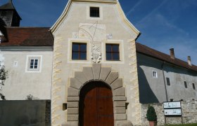 Schloss Kreisbach, © zVg Schloss Kreisbach Eingangstor von Schloss Kreisbach mit Sonnenuhr und Wappen.