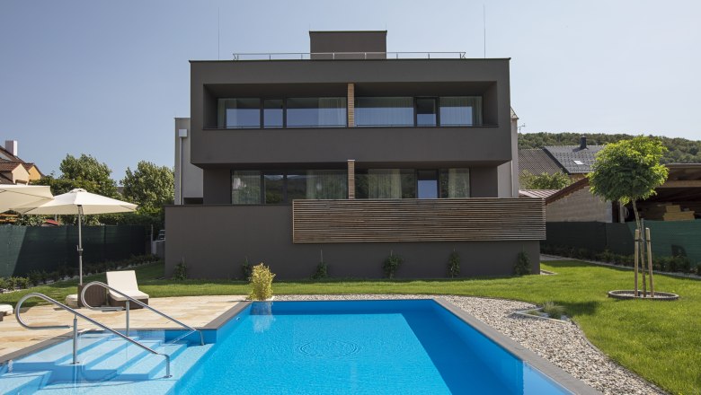 Rückansicht des Hotels, © Weinlodge Siedler Rückansicht eines modernen Gebäudes mit Pool und Garten.