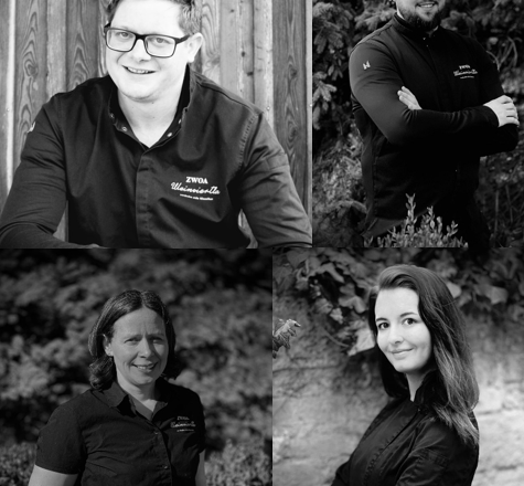 Team, © Die zwoa Weinviertla Vier Personen in Schwarz-Weiß-Porträts, die lächeln und in Arbeitskleidung posieren.