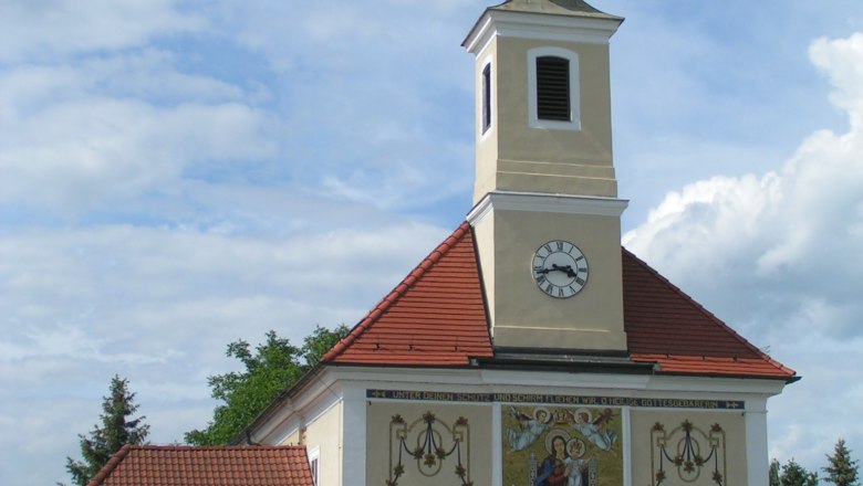 Wallfahrtskirche Maria Ellend, © Gemeinde Haslau Maria-Ellend Wallfahrtskirche Maria Ellend mit Turm und Uhr, verziert mit religiösen Motiven.