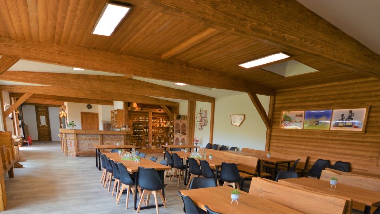 Bienenhaus, © Imkerei Stögerer, Fotograf Gerhard Kapeller Innenansicht eines rustikalen Raumes mit Holzmöbeln und Dekorationen.