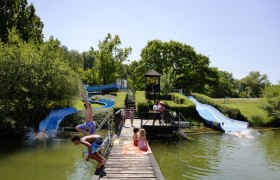 Rutsche im Aubad Tulln, © Alexander Haiden Kinder spielen auf Wasserrutschen im Aubad Tulln.