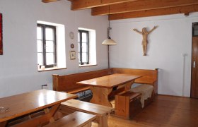 Haus Agnes 1, © Hannes Messmann Rustikaler Raum mit Holzmöbeln, Holzbalkendecke und Wanddekoration.