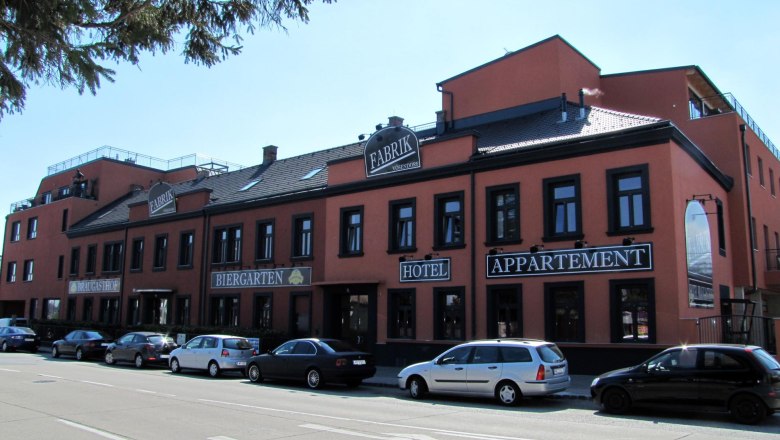 Hotel Braugasthof Fabrik, © Braugasthof Fabrik Außenansicht des Hotel Braugasthof Fabrik mit geparkten Autos davor.