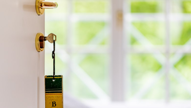 Kavaliershäuser, © Wiener Alpen / Christian Kremsl Ein Schlüssel steckt in einer Tür mit einem Anhänger, auf dem "Kavaliershaus B Burg Feistritz" steht.