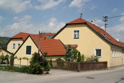 Haus1, © Dürauer Gelbes Haus mit rotem Dach in ländlicher Umgebung.
