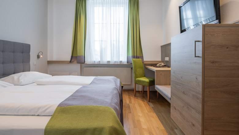 Hotel Unter den Linden E09, © Hotel Unter den Linden Modernes Hotelzimmer mit Doppelbett, Schreibtisch und Fernseher.