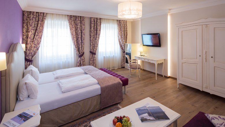 Zimmeransicht im Hotel-Restaurant Zur Post, © Lachlan Blair Elegantes Hotelzimmer mit Doppelbett, Schreibtisch, TV und Obstteller.