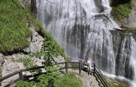 Wasserlochklamm Palfau, © fotosoos.at Eine Frau steht auf einer Treppe vor einem Wasserfall in der Wasserlochklamm Palfau.