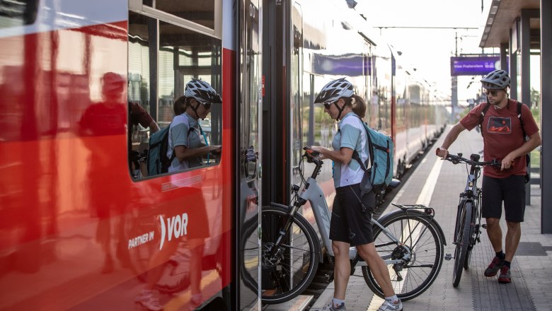 Bahnhof, © Erwin Haiden Zwei Radfahrer steigen mit ihren Fahrrädern in einen Zug ein.