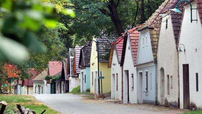 Eichberger und Ahrenberger Kellergasse, © weinfranz.at Reihe von Weinkellern in einer grünen, bewaldeten Umgebung.