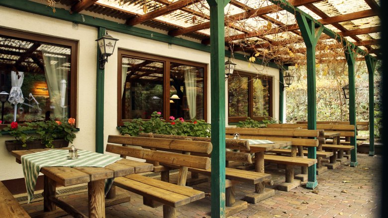 Gastgarten im Waldgasthof Steinbründl, © Familie Kogler-Renner Holzbänke und Tische im Gastgarten eines Waldgasthofs.