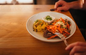 Tafelspitz, © Niederösterreich Werbung/Daniela Führer Teller mit Fleisch, Karotten, Kartoffeln und Dip auf Holztisch.