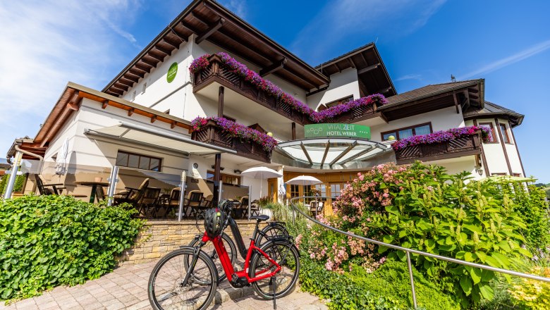 Vitalzeit Hotel Weber, © Wiener Alpen/Martin Fülöp Außenansicht des Vitalzeit Hotel Weber mit Blumen und Fahrrad.