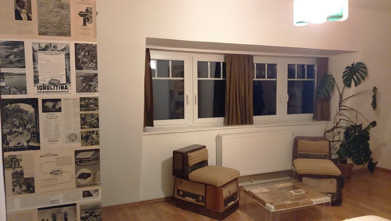 Zimmer im Hotel Binder, © Wiener Alpen Hotelzimmer mit Retro-Möbeln, Zeitungswand und großer Pflanze.