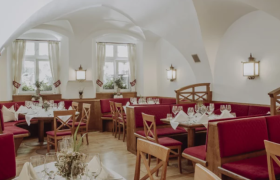 Brauhotel Weitra, © Sabine Biedermann Gemütliches Restaurant mit roten Sitzbänken und Holzmöbeln.