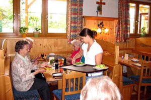 Heuriger zum Hauermandl, © Winzerfamilie Steiner Innenansicht eines traditionellen österreichischen Heurigen mit Gästen und Bedienung.