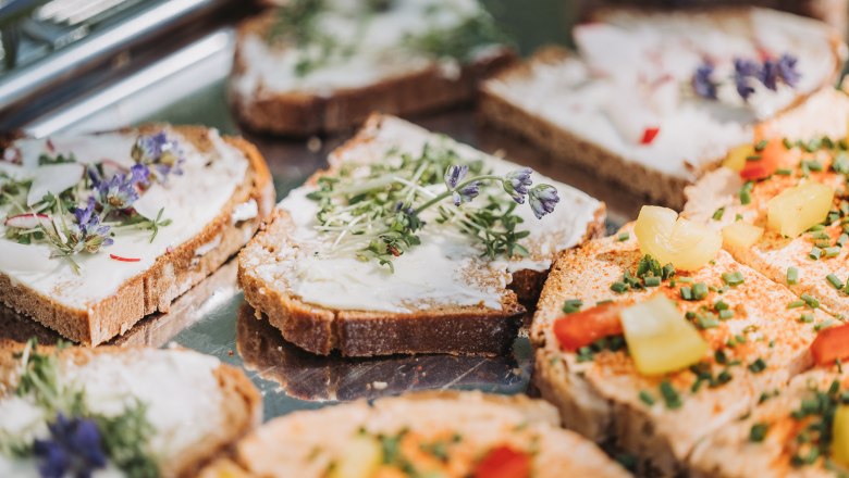 Delikatessen Prokern Partnerfest, © Monika Pölzer Nahaufnahme von belegten Brotscheiben mit Frischkäse, Kräutern und Gemüse.