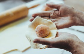 Besonders nachgefragt: die Marillen-Spezialitäten, © Niederösterreich Werbung/David Schreiber Hände formen einen Teig um eine Marille.