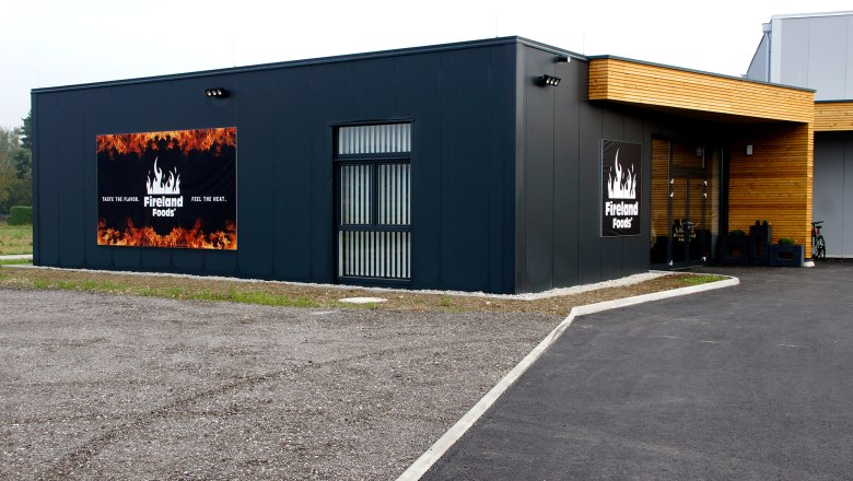 Aussenansicht Fireland Foods, © zVg Außenansicht eines modernen Gebäudes mit Fireland Foods Logo und Slogan.