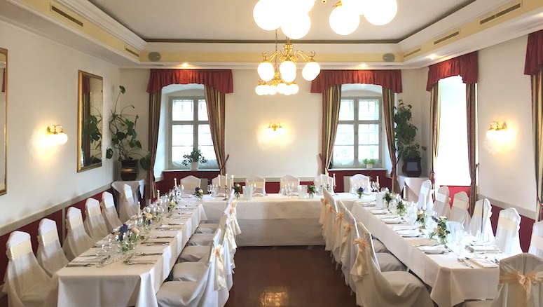 Kleiner Saal im Schloss Gloggnitz, © Brentrup Eleganter Saal im Schloss Gloggnitz, dekoriert für ein Bankett mit weißen Tischdecken und Stühlen.