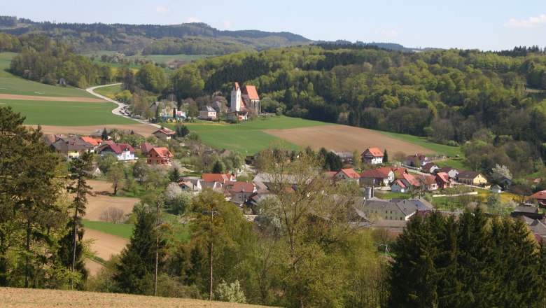 Blick auf Mauer, © zVg Marktgemeinde Dunkelsteinerwald Landschaft mit Dorf, Kirche und Hügeln im Hintergrund.
