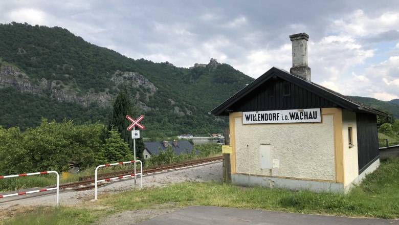 Bahnhof Willendorf, © Donau NÖ Tourismus Kleines Bahnhofsgebäude in Willendorf in der Wachau, umgeben von grünen Hügeln und Bahngleisen.