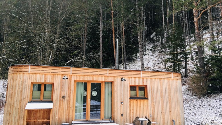 Idyllisch gelegen der Wohnwagon Luna im Winter, © WW Wohnwagon GmbH Kleines Holzhaus im Winterwald mit Schnee bedeckt.
