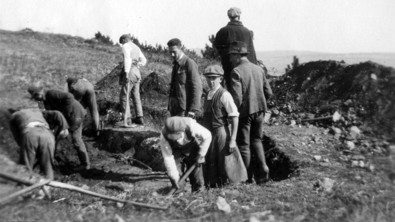 Ausgrabung auf dem Oberleiserberg im Oktober 1926, © Landessammlungen Niederösterreich Schwarzweißfoto von Männern, die auf einem Feld graben.