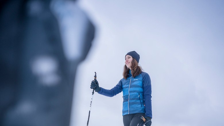 Langlaufen in St. Oswald, © Waldviertel Tourismus, Robert Herbst Eine Frau beim Langlaufen auf einer schneebedeckten Fläche mit Häusern im Hintergrund.