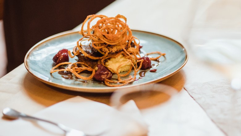 Glacierte Kalbsleber, © Niederösterreich Werbung/David Schreiber Fleischgericht mit Zwiebelringen auf Kartoffelpüree und Sauce.