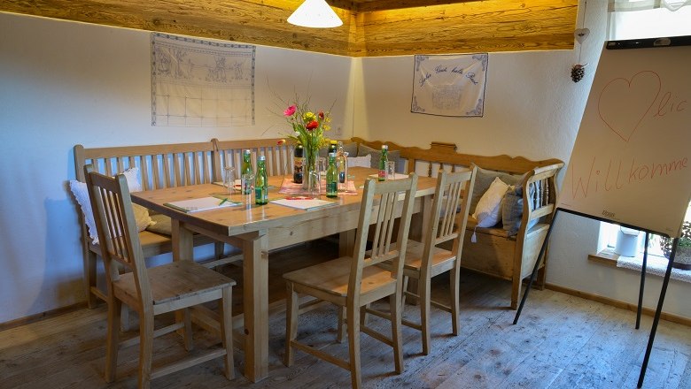 Auch für Seminare sehr gut geeignet, © Berggasthof Mönichkirchner Schwaig Gemütlicher Seminarraum mit Holztisch, Stühlen und Flipchart.